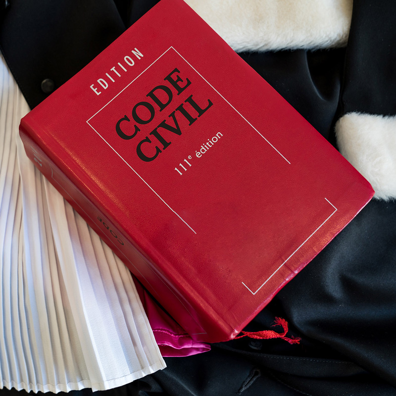 Livre du code civil posé sur une robe d'avocat